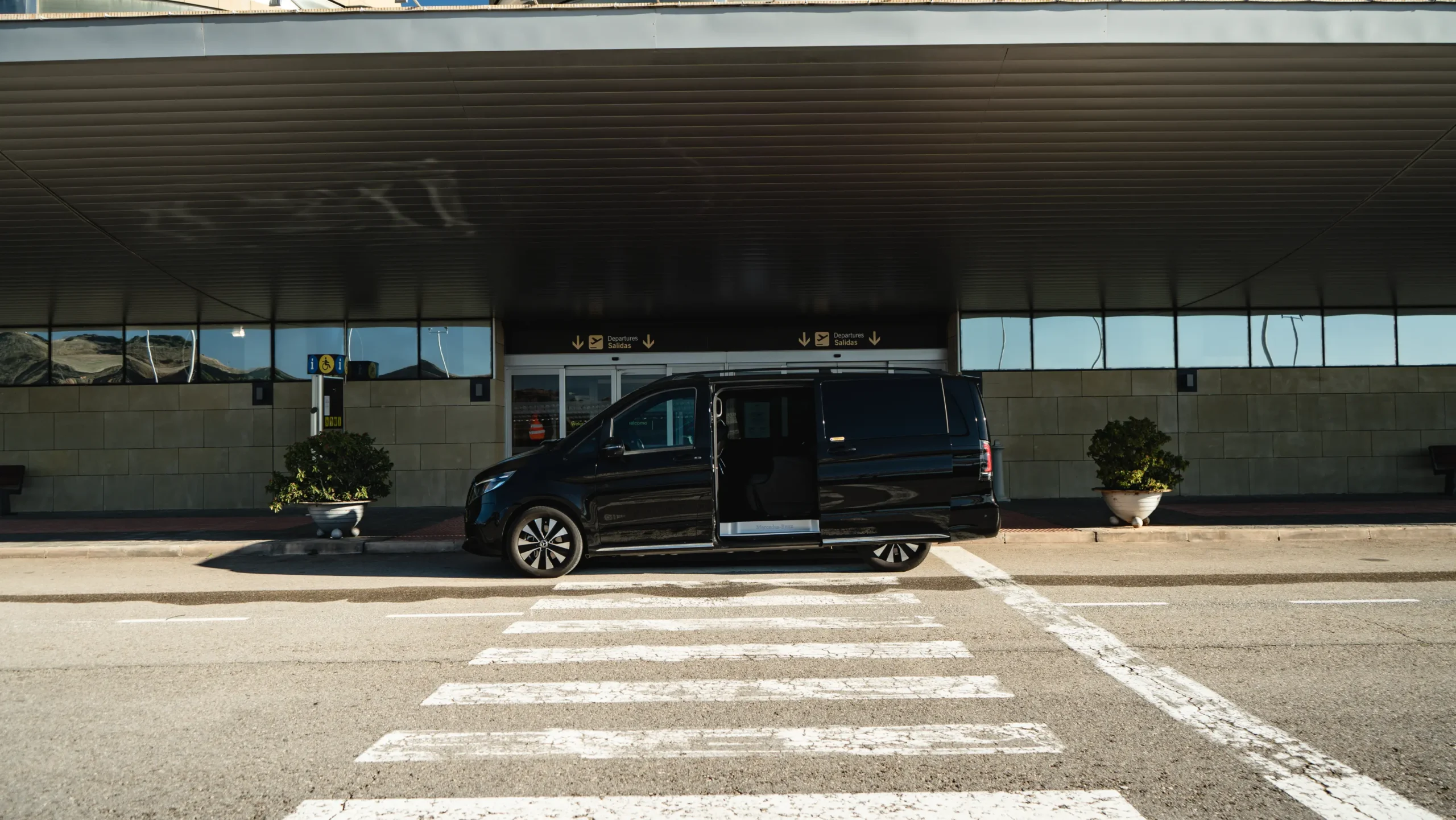 Exterior view of a black Mercedes-Benz V-Class with the side door open, ready for corporate event transportation and MICE logistics by RiojaBlack.