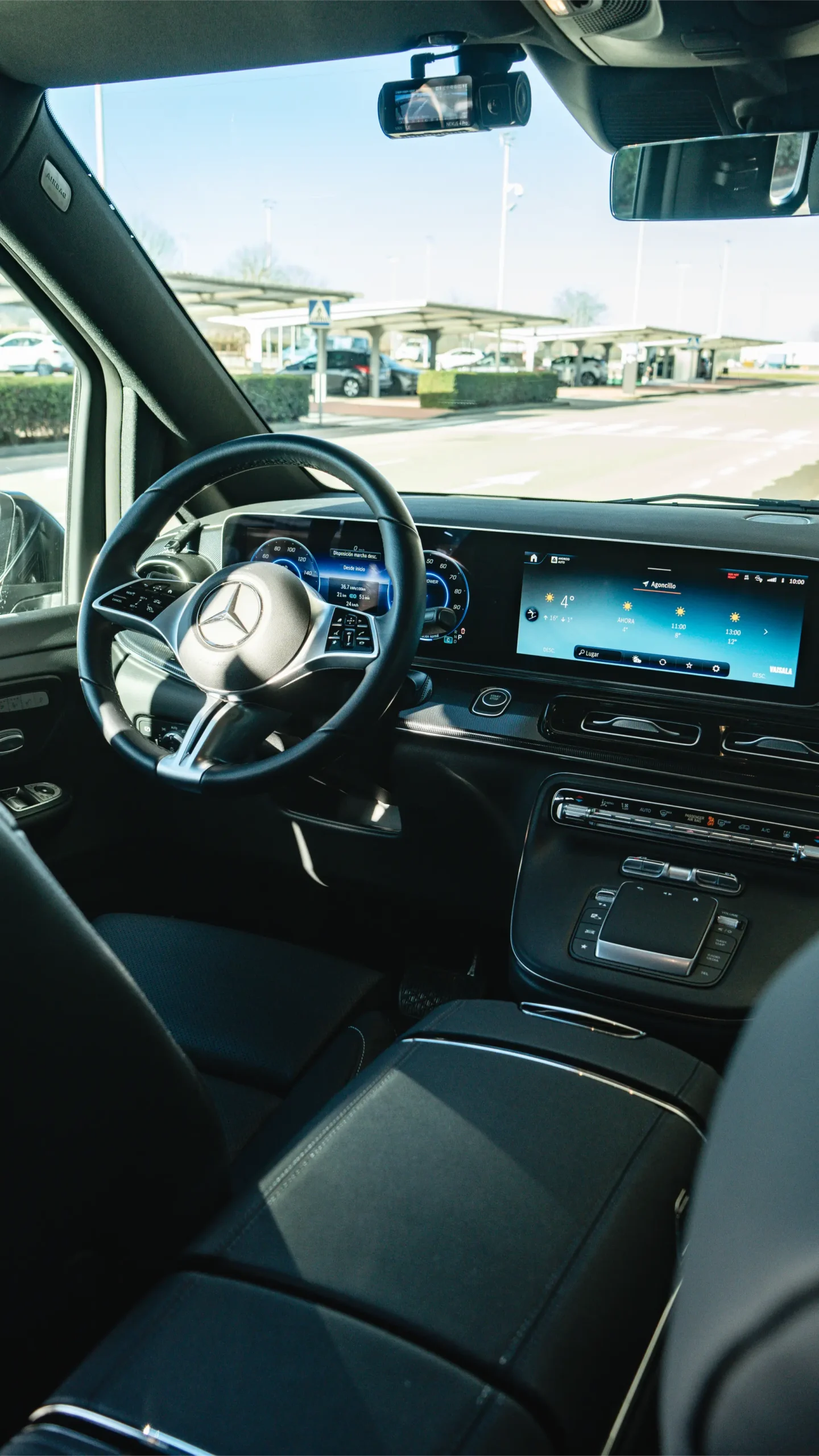Interior view of a Mercedes-Benz EQV from the rear passenger seat, showcasing the premium dashboard and electric driving comfort for hourly chauffeur services.